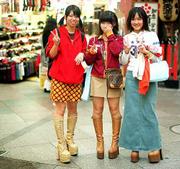 Three young shoppers pause to flash the victory sign while making
their rounds in a mall in Kyoto. In spite of Japan's economy facing
a downward trend, it doesn't seem to hamper young shoppers who fill
trendy shops that sell boots, stockings and new and used clothing.