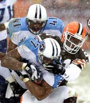 Cleveland's Marquis Smith grabs the facemask of Tennessee running
back Eddie George (27) in the second quarter. George ran for 176
yards and three touchdowns in the Titans' 24-0 victory Sunday in
Cleveland. Smith was called for a five-yard facemask penalty.