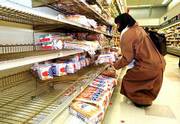 Stella Pang of Newton, Mass., grabs a loaf of bread from what
little is left as New Englanders stock up expecting the biggest
snow storm in at least five years.