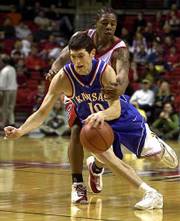 KU's Kirk Hinrich, front, drives past Texas Tech's Jamal Brown.
Hinrich had 13 points and five assists, while Brown had 23 points
and nine assists in the Jayhawks' 94-82 victory on Saturday in
Lubbock, Texas.