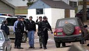 Law enforcement officials line the entrance to the Coachlight Motel
and R.V. Park near Woodland Park, Colo. Acting on a tip,
authorities Monday captured four of the seven convicts who broke
out of a Texas prison nearly six weeks ago and allegedly gunned
down a policeman on Christmas Eve. A fifth inmate killed himself at
the park.