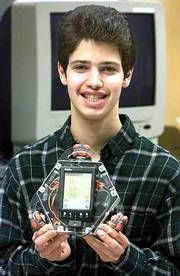 Computer science student Grigoriy Reshko shows a Palm
Pilot-controlled robot that he helped develop at Carnegie Mellon
University's lab. Free software enables the three-wheeled robot to
follow a wall or roam a room for hours, making turns whenever it
nears a wall or furniture, as well as twirl in circle.