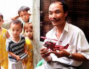 NEIGHBOR CHILDREN WATCH as Hieu Nguyen, 33, shows off a model of a
U.S. helicoptor he and his young crew make from discarded soda and
beer cans in his Saigon home. Years ago he sold his tin models on
the street but today he wholesales them to stores for the tourist
trade. Nugyen's world-wide clientel send him photos of cars,
furniture, motorcycles and most anything that they want duplicated
in tin.