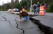 Washington Gov. Gary Locke inspects a fissure in Deschutes Parkway
in Olympia, Wash., caused by Wednesday's earthquake. Friday, Locke
toured areas in Olympia that were damaged in Wednesday's quake.