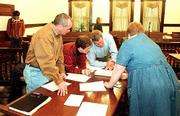The candidate field for the April 3 Lawrence City Commission
general election is settled. Serving as vote canvassers, at
foreground from left, County Commissioner Jere McElhaney, Register
of Deeds Sue Neustifter and County Commissioner Charles Jones,
inspect ballots Friday. At far left is city commission candidate
Adam Mansfield, who picked up 14 votes in the canvass, giving him
the last of six spots on the April ballot.