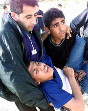 A Palestinian demonstrator wounded by a rubber bullet during
clashes Friday with Israeli soldiers is carried to an ambulance at
Karni, a border crossing between Israel and Gaza Strip.