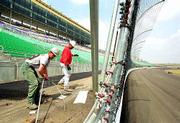 International Speedway Corp. will take possession of the Kansas
Speedway on Sunday, in time to spruce it up for its first auto race
June 2. Christopher Dean, left, and David Myers, workmen for George
J. Shaw Co. of Kansas City, Mo., clean up some leftover sections of
fence Friday near the finish line at the speedway in Kansas City,
Kan.