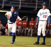 Kansas catcher brent del chiaro unleashes a throw to first base as
pitcher Pete Smart looks on. Texas defeated the Jayhawks, 10-5,
Friday night at Hoglund Ballpark.