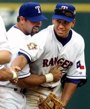 Texas Rangers Ken Caminiti, left, and Alex Rodriguez celebrate
their victory over Anaheim. The Rangers won their home opener 3-2
on Tuesday at Arlington, Texas.