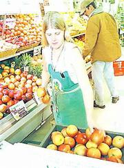 The USDA passed regulations recently that require organic farmers
to meet certain standards to carry an "organic" label. In January
at the Community Mercantile Co-op, 901 Miss., produce assistant
Bridget Meier stocks organically grown apples.