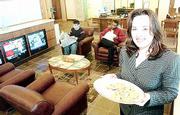 Peoples, 4831 W. Sixth St., is a financial center a prototype
full-service bank with corporate offices, insurance sales,
brokerage services, a bookstore, coffee shop, community gallery,
three television sets and a Sony PlayStation equipped with games.
Angela Cheslic, a receptionist and greeter at Peoples, is ready to
offer fresh-based cookies and coffee to customers.