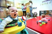 The Kansas Department of Social and Rehabilitation Services is
pushing a program that can help low-income parents who remain in
the work force pay for day-care expenses. Thursday, 8-month-old
Emma Pravecek stretches her face with a yawn at the Children's
Learning Center, 205 N. Mich.