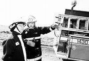 Kanwaka Fire Department Volunteers Bob Rombach, left, and Fire
Chief Chris Lesser survey the scene during a recent call for a
standby unit at a medical helicopter landing in western Douglas
County. Township fire departments rely almost completely on
volunteers to provide protection in the county.