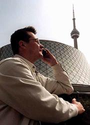 Canada is considering relaxing laws on jamming devices to allow
such places as theatres, restaurants, libraries, hospitals and
private companies to cut off cell phone transmissions on their
property. Here, Dmitri Lopatine calls his wife on his cell phone
outside of Roy Thomson Hall in Toronto, one locale that would
likely use such a device.