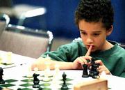 Nicky Henriquez, a first-grader at Quail Run School, ponders his
next move during the United States Chess Federation's
Supernationals tournament. Henriquez is one of 40 Lawrence students
competing this weekend in the national contest in Kansas City, Mo.