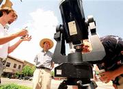 Tim Ivy looks to the heavens with the aid of a filtered telescope
during National Astronomy Day activities. Torry Crass, left, set up
the telescope which filters out 99 percent of the sun's harmful
rays that can damage eyesight Saturday in downtown Lawrence. Crass
and and Reid Nelson, center, are members of Astronomy Associates of
Lawrence, 1082 Malott Hall.