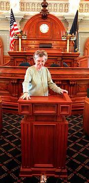 Janet Jones, chief clerk of the Kansas House of Representatives,
demonstrates the new, adjustable lectern in the House chambers at
the Statehouse. The lectern was recently purchased for use in the
House chambers for a price of $9,437.