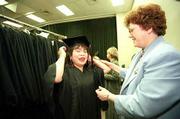 About 120 graduates of the Adult Learning Center received General
Education Development diplomas at Free State High School. Man Gia
"Wendy" Holmes, left, receives help with her tassel Wednesday from
teacher Ann Dillehay before the GED graduation ceremony.