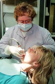 Donita bouton, secretary of the Douglas County Dental Coalition,
says a new Lawrence clinic will fill a void among low-income
residents. Bouton is shown Thursday cleaning the teeth of Taunya
Cole, Lawrence, at Dr. John Hay's office, 10 E. Ninth St.