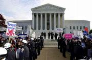 The U.S. Supreme Court ended its term after issuing rulings in 85
cases, including Bush v. Gore, which ultimately cleared the way for
George W. Bush to become president. Late last year, when Bush v.
Gore was being argued in front of the court, Republican supporters
of Bush, left, were kept separated by police from Democratic
supporters of Al Gore, right, in front of the court building in
Washington.