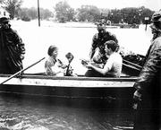Barbara Crews cradles her infant son, Chip, as she and her husband,
Ray, are evacuated from their North Lawrence home. Gib Francis,
standing behind boat at left, helped get them to safety. Steve
Randall, an unrelated child, was also evacuated by boat. The man at
right is unidentified.