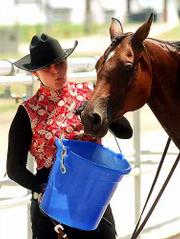 Allison Mundy, Stillwell, tries to cool down her Arabian horse,
"Comarah," in the scorching heat at the Douglas County 4-H
Fairgrounds. Mundy and other area horsemen were competing Tuesday
to qualify for the Kansas State Fair in Hutchinson in September.
