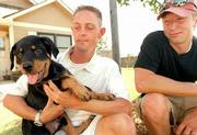 A rottweiler puppy named Rah is back home with his owner, Aaron
Wright, left, after Wright's friend Paul Nuzum, right, helped
search for the dog. Rah was stolen from Wright's truck Sunday
night. Wright and Nuzum posted fliers and sent out thousands of
e-mails to help locate the dog, which was eventually returned.