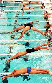 The Second heat of the boys 15-over division dives into the pool
prior to their race. The event took place during the Roger Hill
Invitational swim meet Sunday at the Lawrence Indoor Aquatic
Center.
