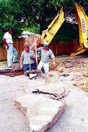 Kansas Department of Health and Environment personnel dig up the
ground near Priscilla's, 1206 W. 23rd St., searching for a possible
source of gas fumes making their way into the sewer system. From
left Monday are Hersie Brooks, an employee with Environmental
Geoscience & Engineering Inc., Kansas City, Kan., and Mike
Eddings and Dan Wells, both environmental geologists with KDHE.