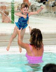 After working up some nerve, Mckenzie Brungardt, 3, jumps into the
arms of her mother, Lori, at Thursday's swim lesson at the Lawrence
Indoor Aquatic Center.