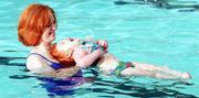 Sherry Draper and daughter Amber, 3, share a laugh as they practice
floating during swimming lessons at the Lawrence Indoor Aquatic
Center.