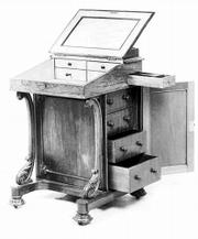 This Victorian carved rosewood davenport desk was made about 1850.
The small top drawer is opened by a secret button. It sold for more
than $3,000.