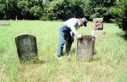 Henry Flory looks at the tombstone of Jacob Ulrich in the Ulrich
Cemetery nine miles south of Lawrence. Ulrich's home was burned by
Quantrill's raiders in 1863 and he died the following December at
the age of 60.