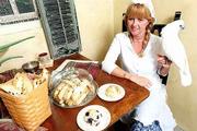 Every morning, Karen Wagner bakes fresh biscotti and scones for
four Lawrence businesses. Her husband, Orlin, started the
home-based business O&K Kitchen in the early 1990s. Karen
Wagner displays a few of her products with the assistance of her
bird, Maxi, who doesn't help with the cooking.