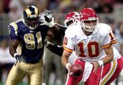 Chiefs quarterback Trent Green (10) rolls out to hand off as St.
Louis' Leonard Little pursues. The Rams defeated the Chiefs, 21-17,
Friday night in St. Louis.