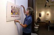 Maria Martin hangs the 2001 Lawrence Indian Arts Show poster in the
meeting room at the Lawrence Public Library, 707 Vt.