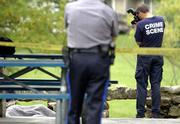 Detective Dan Ward with the Lawrence Police Department investigates
the scene at Clinton Park where the body of a woman was discovered.
Rachelle Conrad's body was found Friday morning in a shelter at the
park, at Fifth and Alabama streets.