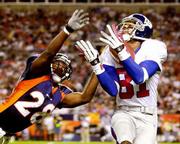 New York wide receiver Amani Toomer, right, pulls in a 43-yard
touchdown pass ahead of Denver safety Kenoy Kennedy. The Broncos
beat the Giants, 31-20, on Monday in Denver.