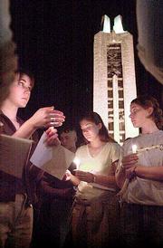 Mara Richards, from left, Cindy Riggins and Lana Seibel huddle
together holding candles in remembrance of victims in Tuesday's
terrorist attacks on the United States. Richards, Riggins and
Seibel were among an estimated 1,000 people that gathered for a
vigil Thursday near the Campanile at Kansas University, according
to university spokeswoman Lynn Bretz.