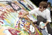 Expressing themselves through art, Kansas University students like
senior Andrew Vratil, Overland Park, work on a collaborative
memorial in reflection of the terrorist attacks on the East Coast.
Vratil was among those Friday at the Art and Design Building who
were painting a 30-foot canvas. Organizer and junior Lisa
Thalhammer, St. Louis, said she hoped to display the painting in a
campus gallery.