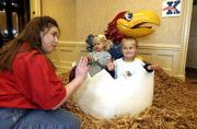 Kansas University Alumni Center activities director Suzanne Doyle,
left , gets ready to give a high five to Triston Reynolds, 5, as
Triston's sister, Emma Reynolds, 2, plays with a Jayhawk sticker.
The Reynolds got their picture taken during festivities Saturday at
KU's first all-university open house.