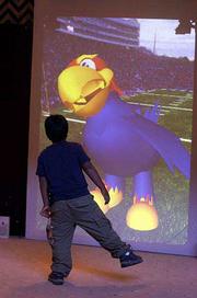 A young visitor does the Hokey Pokey in front of the Kansas
University Cyber Jay at Murphy Hall. He was one of the more than
20,000 people who turned out Saturday for KU's open house.