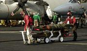 Aviation ordnancemen move laser-guided bombs to waiting aircraft on
the USS Carl Vinson, operating in the Arabian Sea, in preparation
for strikes against military targets and Osama bin Laden's training
camps inside Afghanistan.