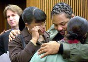 Anthony Michael Green gets a hug from his sister, Sharon Pascol,
right, and friend Patricia Everson after the rape conviction
against him was vacated by a Cuyahoga County judge in Cleveland.
DNA testing of 13-year-old evidence proved Green could not have
committed the crime. In the left background Thursday is attorney
Barry Scheck, who helped prove Green's innocence.
