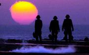 USS Theodore Roosevelt deck crewmembers are silhouetted against the
dawn sun as they wait to launch an aircraft Saturday. The Roosevelt
is one of the many ships in the Arabian Sea involved in the attacks
in Afghanistan. The CIA is contemplating using covert missions to
assassinate terrorists in Afghanistan.