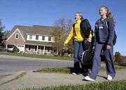 Headed home for the weekend with orchestra instruments and bookbags
in tow are Southwest Junior High students Aarynne Struble, ninth
grade, left, and Adrienne Struble, seventh grade. The sisters
walked along Turnberry Drive Friday in southwest Lawrence, an area
of town experiencing a growth explosion.