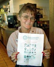 Gail Sanders, a waitress at a truck stop in Cordele, Ga., holds a
terrorist wanted poster. Sanders keeps photos of suspected
terrorists beneath the counter and scrutinizes every customer who
enters her busy south Georgia truck stop.
