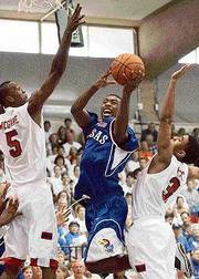 Kansas' Keith Langford, center, launches a shot between Houston's
Jeremee McGuire, left, and Terry Price. Langford had 11 points and
five rebounds in KU's 95-78 victory over UH on Tuesday in Lahaina,
Hawaii.