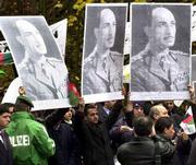 Afghan royalists hold up posters of King Mohammad Zaher Shah during
a rally in Koenigswinter, near Bonn, Germany. Afghan factions
opened talks Tuesday on how to share power and secure peace once
the Taliban are defeated in Afghanistan.