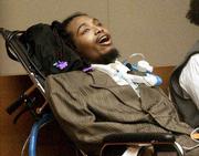 Allen Toshavik testifies from his wheelchair and with the aid of a
respirator against defendant John John McGautha